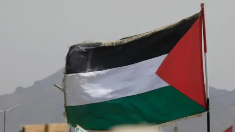 EPA A FALESTINIAL FLAG FLUTRS during a protest against the United States and Israel, in Sana'a, Yemen.