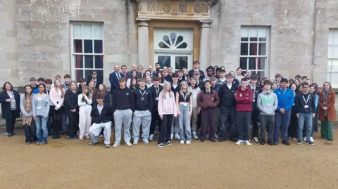 Swindon Borough Council Young people in casual clothes stood in front of a stately home