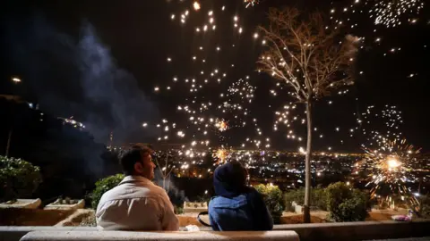AFP via Getty Images Iranians watch fireworks during the Wednesday Fire feast, or Chaharshanbeh Soori, held annually on the last Wednesday eve before the Spring holiday of Nowruz, in Tehran, on March 18, 2025. 