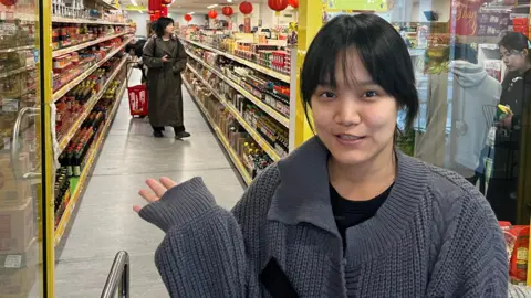 Cathy standing outside Sing Kee supermarket