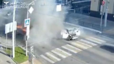 Car hit by drone seen with all its doors open surrounded by smoke