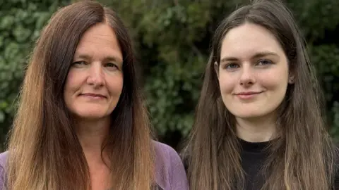 BBC Two women stand in a garden. Both are looking into the camera.