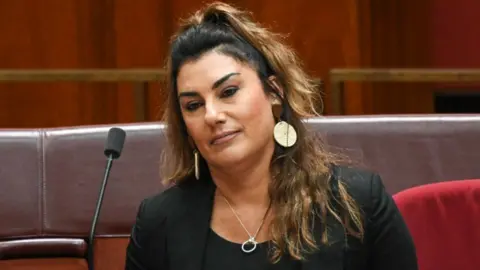 Lidia Thorpe sitting in front of a microphone in the Australian senate chamber