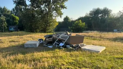 Daniel Wheatley A pile of rubbish left on an open patch of grass