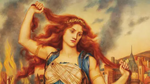 Trustees of the De Morgan Foundation A grand painting with vivid colours. It shows a ginger haired young woman with very long hair. She is holding her hair up and looking down. There are buildings behind her, they look religious. 