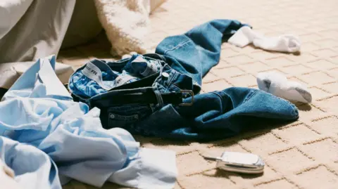Getty Images Man's Clothes on Bedroom Floor.