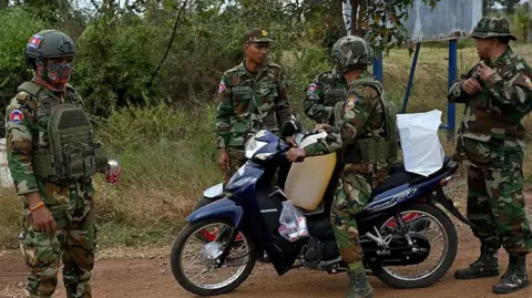 AFP via Getty Images Soldiers stop for a rest during clashes along the Cambodia-Thailand border in Cambodia's Siem Reap province on December 10, 2025