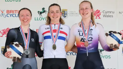 Anna Morris, Zoe Backstedt & Elynor Backstedt on the podium with medals