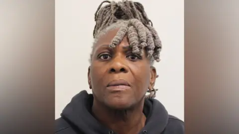 A mugshot of a Janice Nix against a plain background. She is wearing a dark grey hooded sweatshirt. 