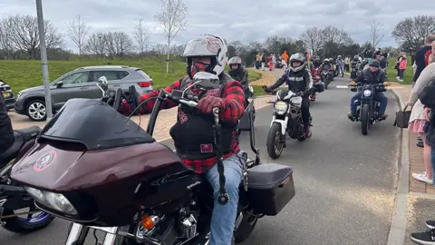 Dozens of bikers assemble in a car park ahead of the funeral