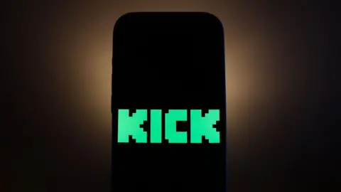 Getty Images The bright green pixel-style Kick logo is displayed on a black smartphone screen.
