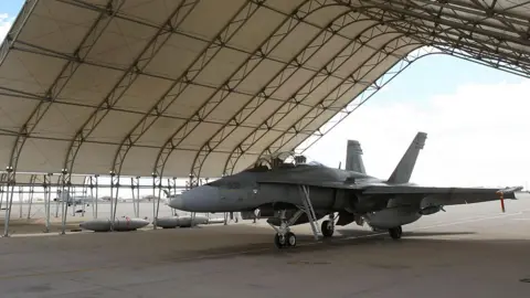 Getty Images/David McNew A Canadian hornet under shelters on the tarmac at Naval Air Facility (NAF) El Centro near El Centro, California