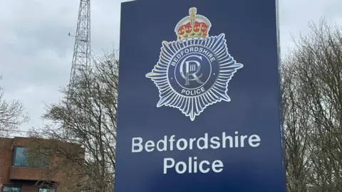 A blue Bedfordshire Police sign outside their headquarters