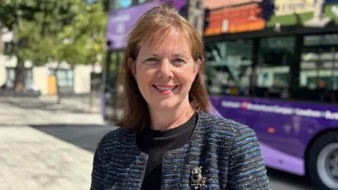 East Midlands Mayor Claire Ward standing in front of a Nottingham City Transport bus on Sneinton Market
