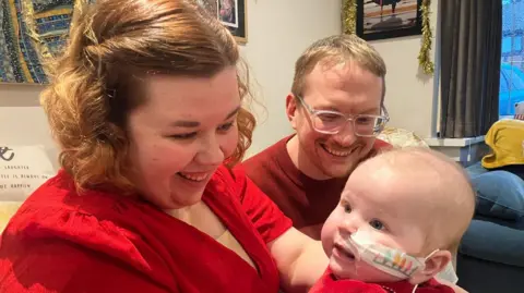 Parents Emma and Mike with their six-month-old daughter Amelia.