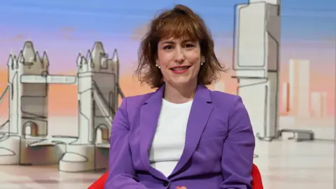 The Louth and Horncastle MP, Victoria Atkins, smiling as she sits in a TV studio. She is wearing a purple blazer and a white shirt.