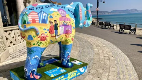 A decorated elephant looking out to sea