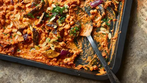 A top down view of a baking tray with chickpea romescu traybake