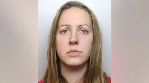 Cheshire Constabulary Lucy Letby, with shoulder length blonde hair and a red jumper, is pictured for her police mugshot 