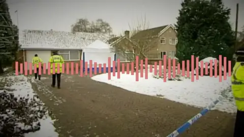 Una Crown's bungalow with police officers on the drive and a white police tent at the door.