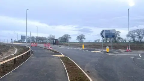 BBC/Ollie Conopo Newly built road with barriers visible