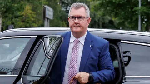 PA Media Donaldson has short grey hair and is wearing a blue suit as he gets out of a black car.