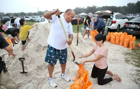 Getty Images Los residentes locales llenan sacos de arena en Kissimmee, Florida