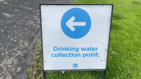 BBC/Daniel Sexton A Thames Water sign with an arrow pointing to a 'Drinking Water Collection Point'