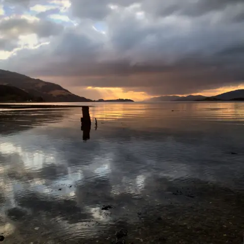 Brian Colston A loch at sunset with hills and clouds in the background