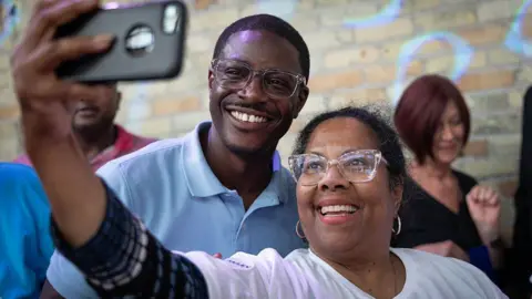 David Crowley poses for a selfie alongside a supporter while campaigning to be the Democratic candidate for Wisconsin governor