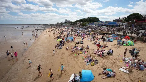 Getty Images People enjoy the beach in Cleethorpes during Armed Forces Day in 2025. There are people paddling in the sea, while others are enjoying the sunshine.
