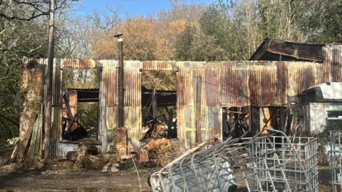 Metal panels that make up the building brown and damaged after the fire on Saturday.