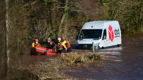 PA Media Emergency services rescue a DPD delivery van driver stranded in flood water in Newbridge on Usk, in Wales, after ten flood warnings and 41 flood alerts were issued for areas in Wales which were hammered by heavy rain throughout Friday.