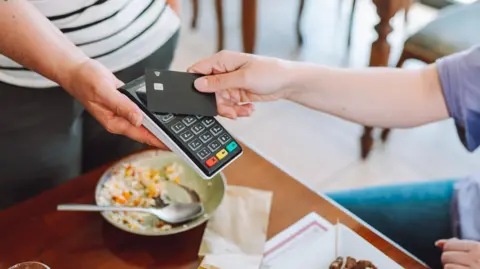 A person pays with a credit card in a restaurant