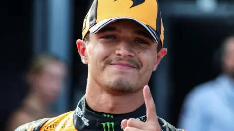 McLaren's Lando Norris holds up his index finger in celebration after taking pole position for the Hungarian Grand Prix