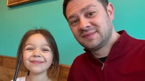 Jamie sat with his daughter Vesper taking a selfie.