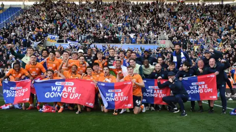 Cardiff City players and staff celebrate promotion in front of their fans
