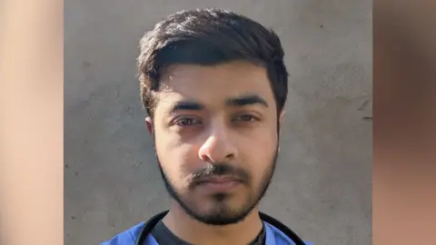 A picture of Raahat Shah, who is wearing a blue surgical uniform and a stethoscope around his neck.