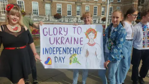 Antonina Grebeniuk Two women holding a banner that says Glory to Ukraine Independence Day