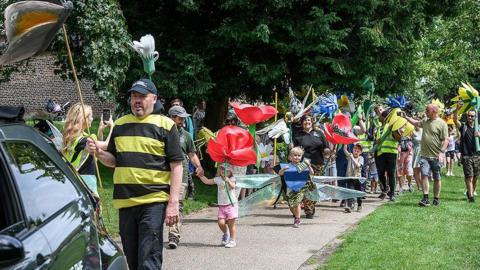 Pollinator parade of families walking through the park dressed as their favourite insects