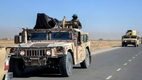  A military patrol in Shorabak district near the Afghanistan-Pakistan border on October 12. A man with his face covered stands atop a military vehicle.