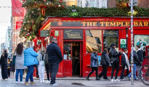 Bloomberg via Getty Images Temple Bar pub and street area in Dublin, Ireland, with people gathered outside