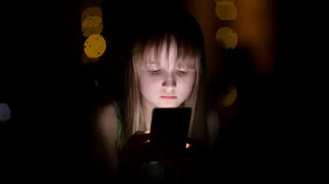 A child looking into her mobile phone