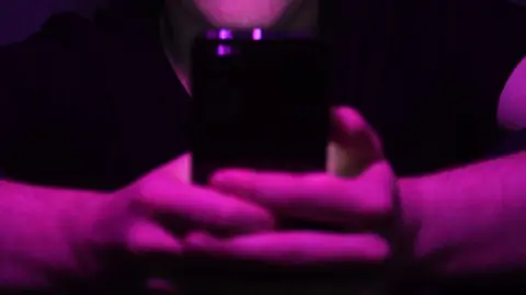 Generic image showing a close up of a man's hands holding a mobile phone