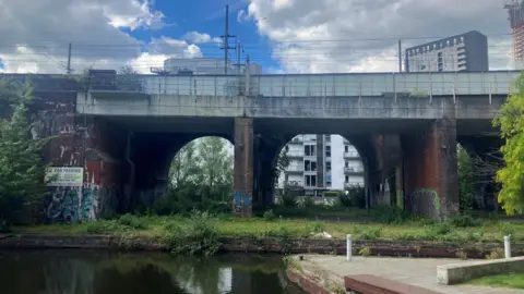 Photograph of a series of railway arches next to canals in Castlefield on the edge of Manchester city centre.