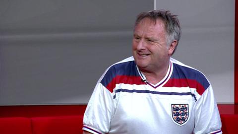 A smiling Paul Freeman in an England shirt looking to the left of the camera