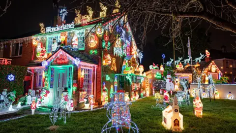 A house in Brentry, Bristol, which is covered in Christmas Lights. Lights spell out the word "Wonderland" at the top, and reindeer light figures can be seen on the rooftop. There are snowmen, Santa, stars and snowflake lights all over the house. They are all different colours. 