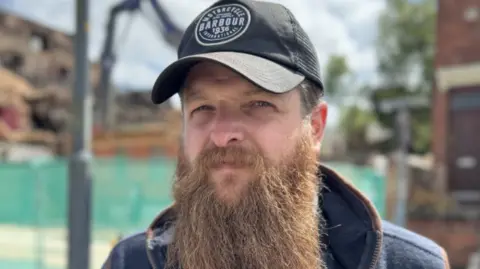 A bearded man in a cap