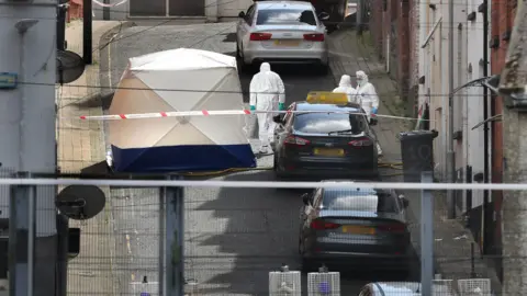 Margaret McLaughlin, forensic scientists in white suits on Harvey Street, white tent on the street in front of a property, police cordon and a vehicle blocking the street