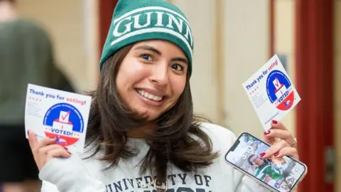 Getty Images A voter presents the sticker 'I VOTED!' during early voting in Illinois